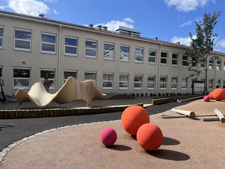 en bygning med en stor plen og en stor skulptur foran den