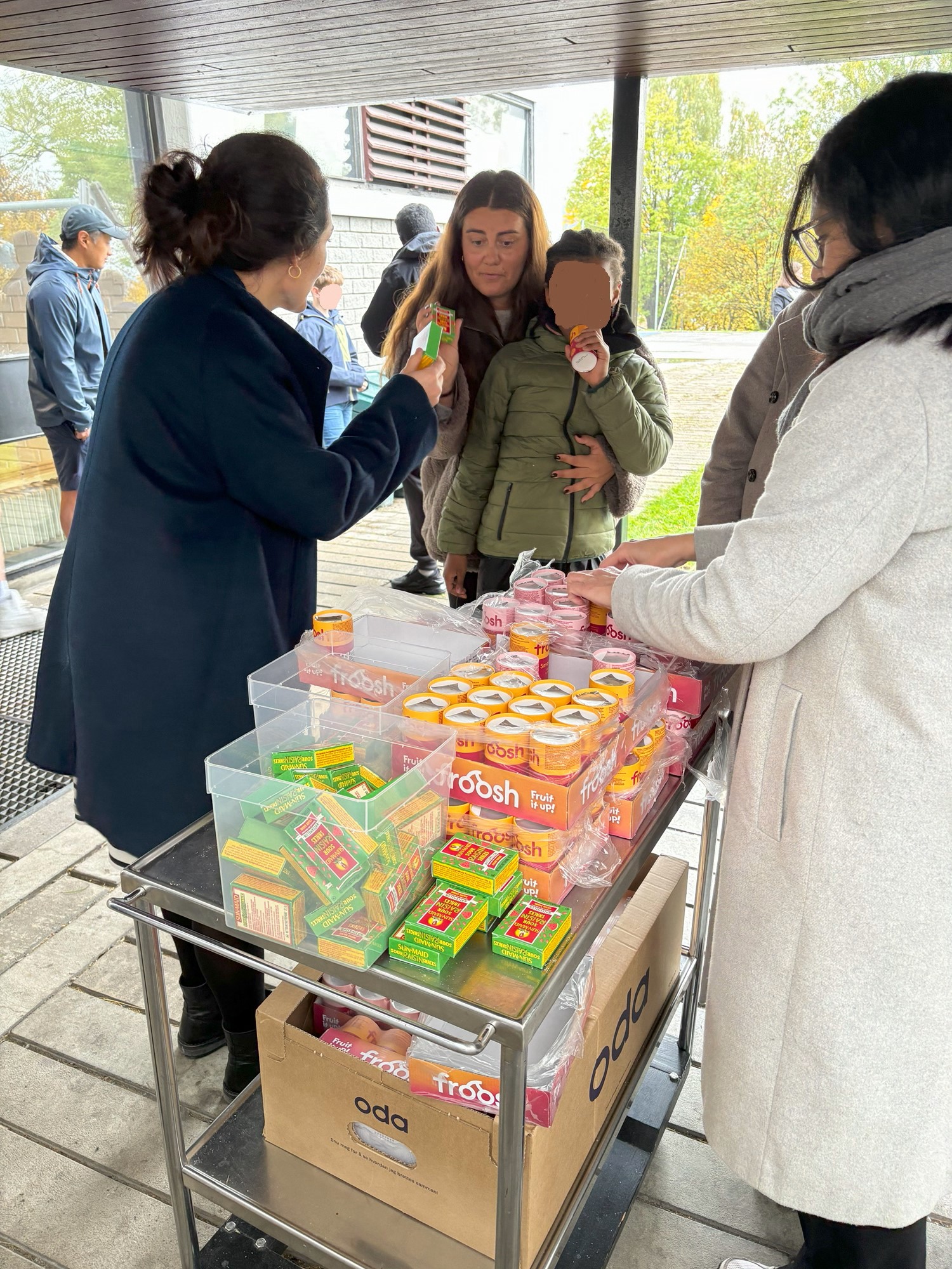 en gruppe mennesker som står rundt et bord med mat på