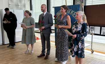 en gruppe mennesker som står i et rom